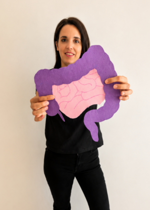 Nutricionista digestiva mostrando un modelo anatómico del intestino en consulta
